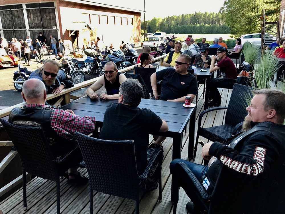 Verstaan terassi täynnä vieraita kesäillassa.